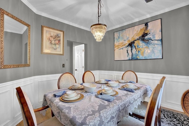 dining room featuring hardwood / wood-style floors, ornamental molding, and a notable chandelier