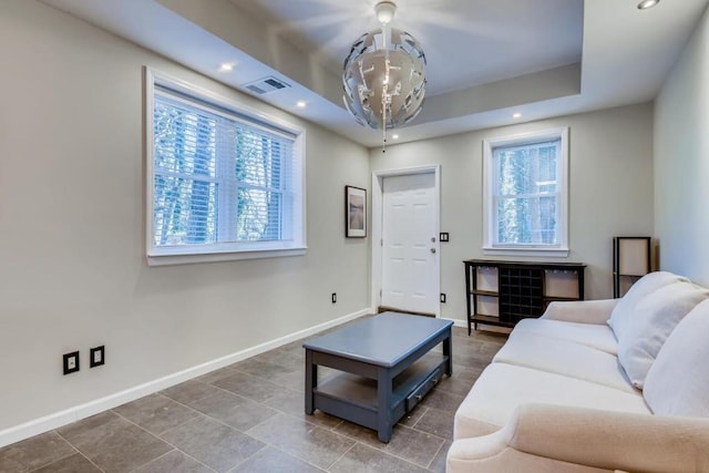 living area featuring visible vents, recessed lighting, a raised ceiling, and baseboards