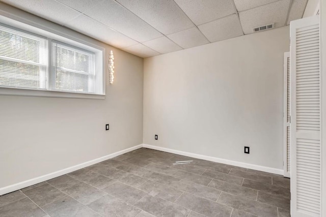 spare room with visible vents, baseboards, and a drop ceiling