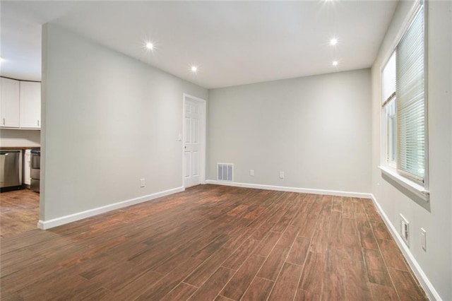 spare room with dark wood-style floors, visible vents, recessed lighting, and baseboards