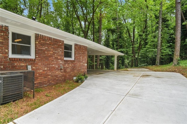 view of patio featuring an attached carport, central AC unit, and concrete driveway