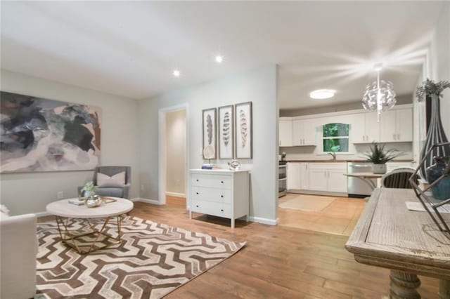 living area featuring light wood finished floors, recessed lighting, and baseboards