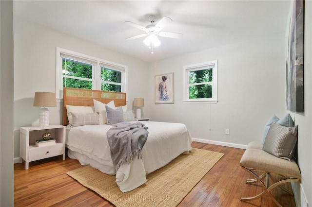 bedroom with light wood-type flooring, baseboards, and ceiling fan