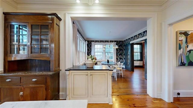 kitchen with crown molding, a chandelier, and light hardwood / wood-style floors