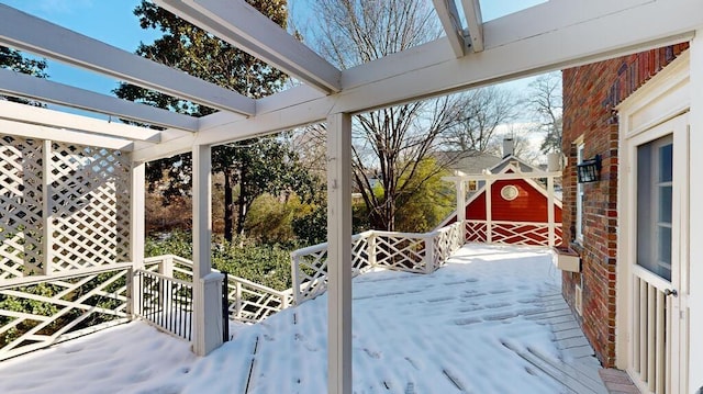 snow covered deck featuring a shed