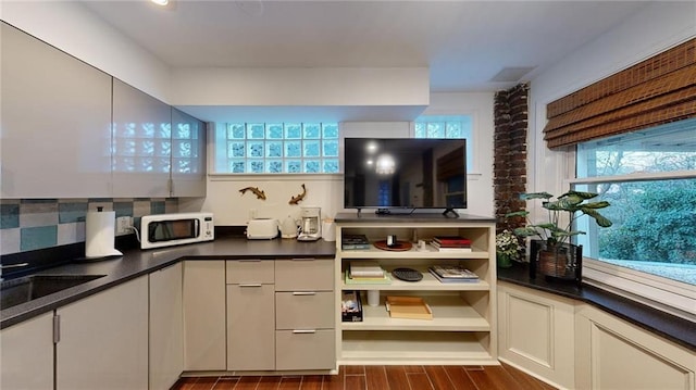 kitchen with tasteful backsplash, dark hardwood / wood-style floors, and sink