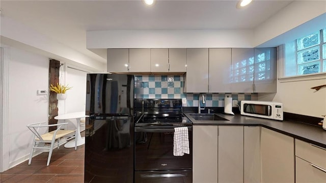 kitchen featuring tasteful backsplash, sink, gray cabinets, and black appliances