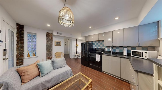 kitchen featuring gray cabinets, pendant lighting, tasteful backsplash, sink, and black appliances