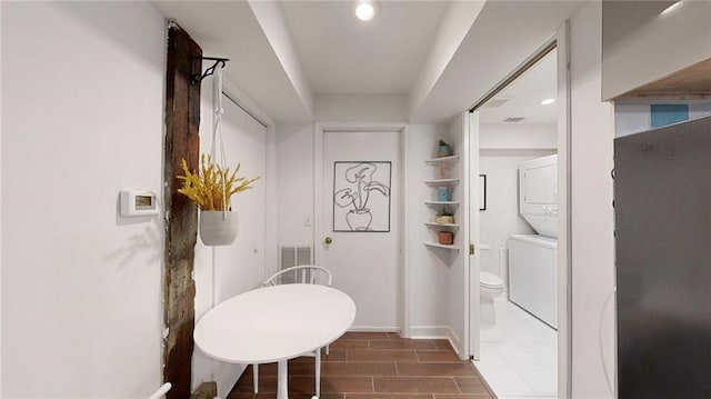 interior space featuring stacked washer and clothes dryer