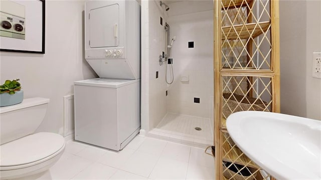 bathroom featuring sink, tile patterned flooring, stacked washer and clothes dryer, tiled shower, and toilet