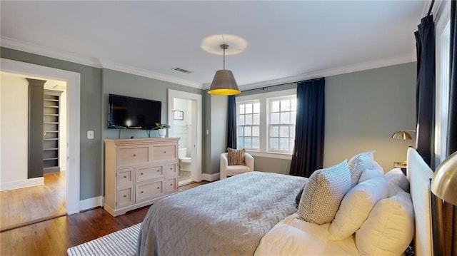 bedroom with ornamental molding, dark hardwood / wood-style flooring, and ensuite bath