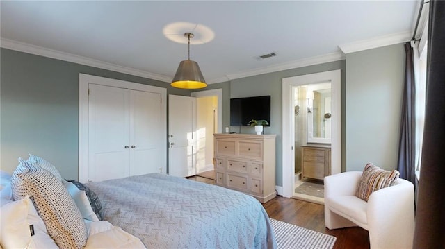 bedroom with dark wood-type flooring, ensuite bath, crown molding, and a closet