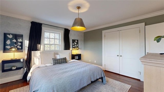 bedroom with crown molding, dark wood-type flooring, and a closet