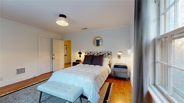 bedroom with crown molding and wood-type flooring