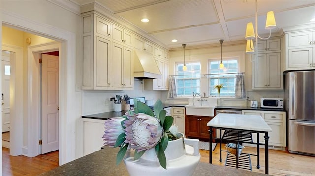 kitchen with sink, custom exhaust hood, decorative light fixtures, light hardwood / wood-style flooring, and appliances with stainless steel finishes