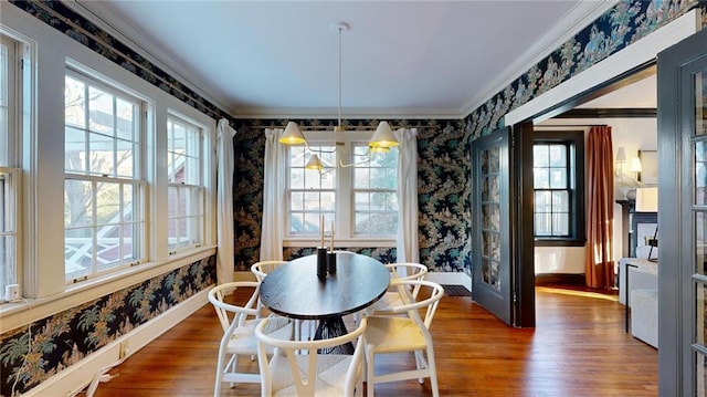 dining room with crown molding, dark hardwood / wood-style floors, and an inviting chandelier