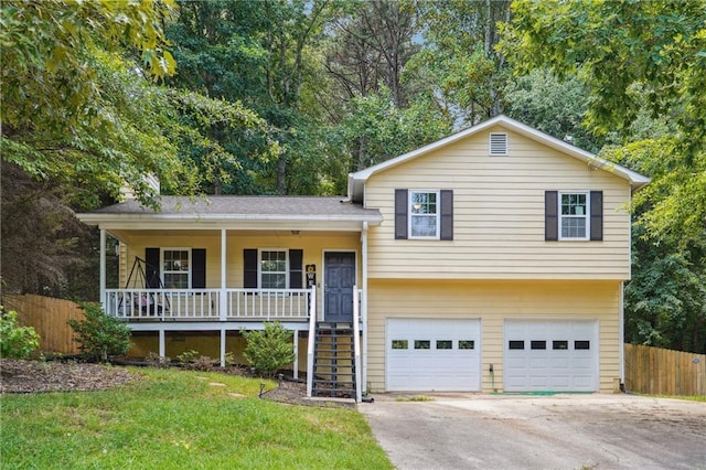 tri-level home with a front yard, a porch, and a garage