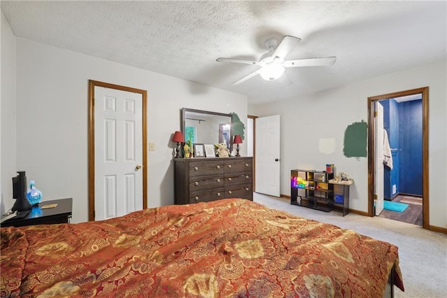 carpeted bedroom featuring a textured ceiling, ceiling fan, and ensuite bathroom