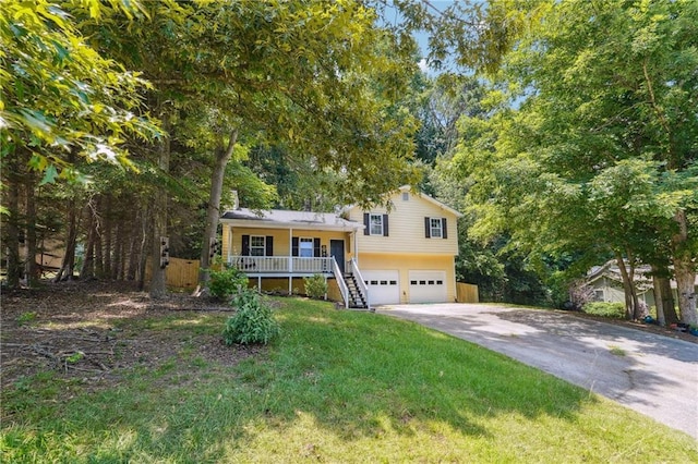 tri-level home featuring a garage, covered porch, and a front lawn