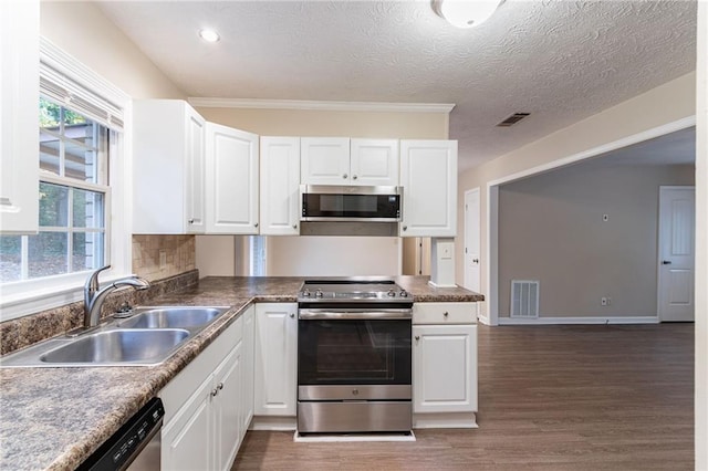 kitchen with a textured ceiling, appliances with stainless steel finishes, sink, and white cabinets