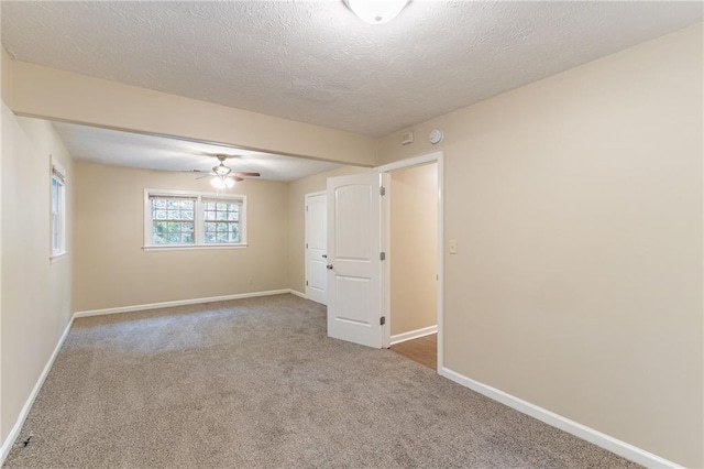 carpeted empty room featuring a textured ceiling and ceiling fan