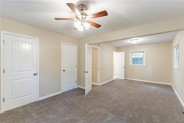 unfurnished bedroom with carpet flooring, a textured ceiling, and ceiling fan