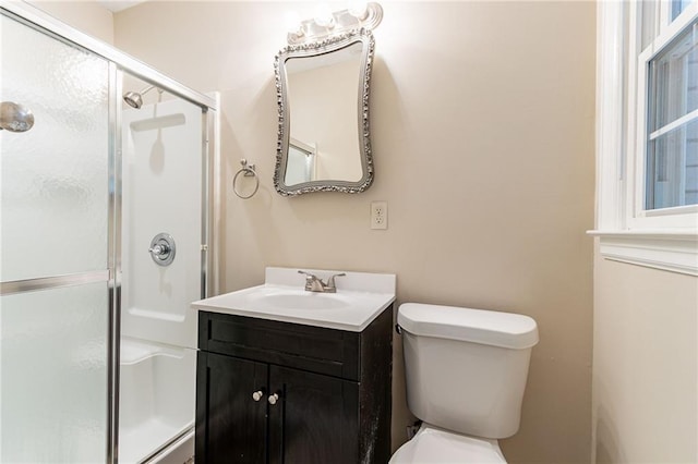 bathroom with walk in shower, vanity, and toilet