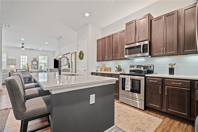 507 Bishop Ln, Woodstock, GA 30188 - kitchen with stainless steel appliances, a sink, light countertops, a kitchen bar, and recessed lighting
