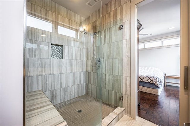 bathroom featuring visible vents, ensuite bath, and a tile shower