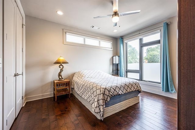 bedroom with dark wood finished floors, visible vents, baseboards, and ceiling fan