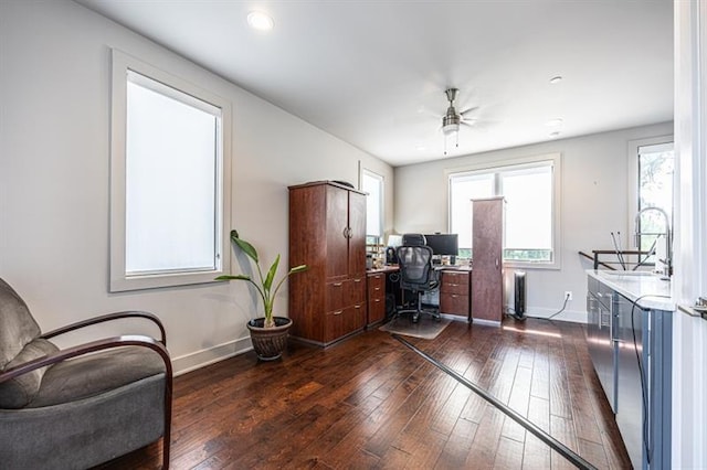 office space with dark wood finished floors, ceiling fan, radiator heating unit, and baseboards