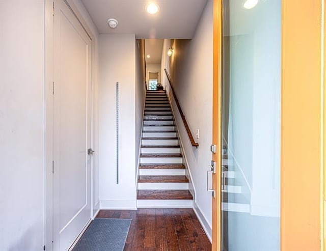 staircase featuring recessed lighting, baseboards, and wood-type flooring