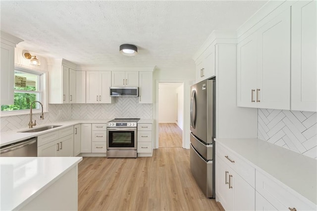 145 Devilla Trce, Fayetteville, GA 30214 - kitchen with appliances with stainless steel finishes, a sink, tasteful backsplash, light countertops, and a textured ceiling