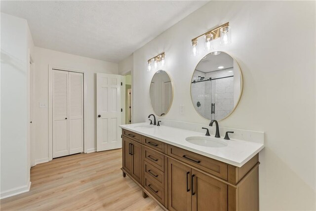 145 Devilla Trce, Fayetteville, GA 30214 - full bath featuring double vanity, wood finished floors, tiled shower, a closet, and baseboards