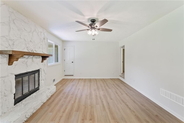 145 Devilla Trce, Fayetteville, GA 30214 - unfurnished living room with light wood finished floors, ceiling fan, a stone fireplace, and baseboards