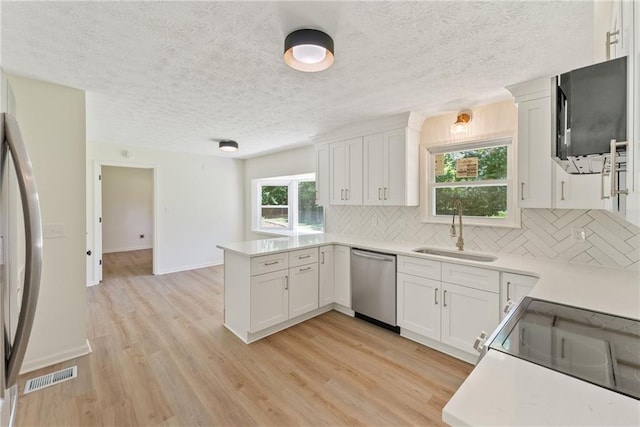 145 Devilla Trce, Fayetteville, GA 30214 - kitchen with stainless steel dishwasher, a sink, fridge, a peninsula, and decorative backsplash