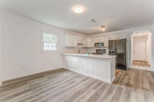 53 Knight Dr, Cedartown, GA 30125 - kitchen with stainless steel microwave, black refrigerator with ice dispenser, range with electric stovetop, a textured ceiling, and light countertops