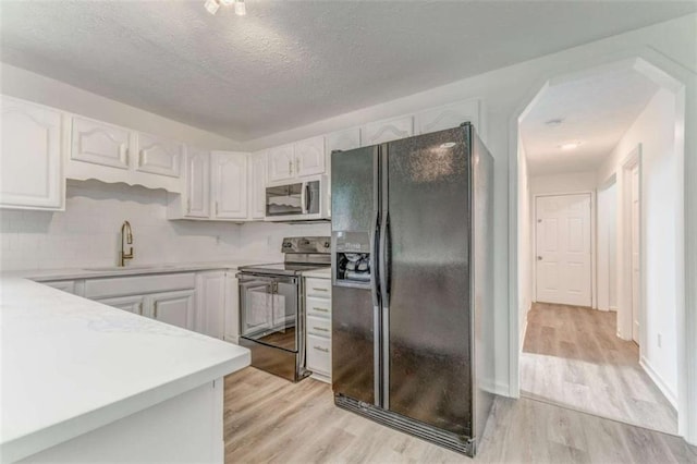 53 Knight Dr, Cedartown, GA 30125 - kitchen featuring black appliances, light countertops, light wood-type flooring, a textured ceiling, and white cabinets