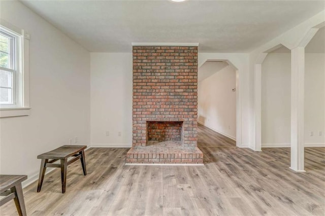 53 Knight Dr, Cedartown, GA 30125 - unfurnished living room featuring wood finished floors, a brick fireplace, and arched walkways