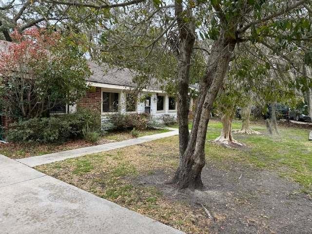 view of property hidden behind natural elements featuring a front yard