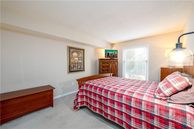 bedroom with light colored carpet and a textured ceiling