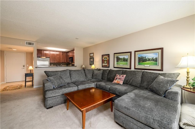 living room featuring light carpet and a textured ceiling