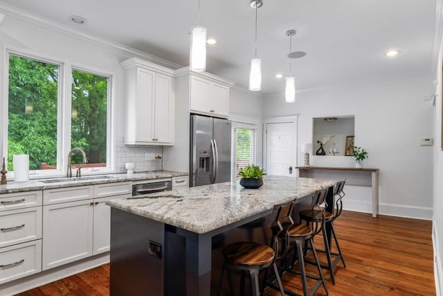 1038 Saint Charles Ave, Atlanta, GA 30306 - kitchen featuring stainless steel fridge, a sink, ornamental molding, white cabinets, and a breakfast bar
