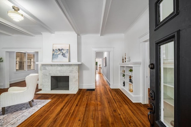 1038 Saint Charles Ave, Atlanta, GA 30306 - living room with beamed ceiling, wood finished floors, a fireplace with flush hearth, baseboards, and ornamental molding