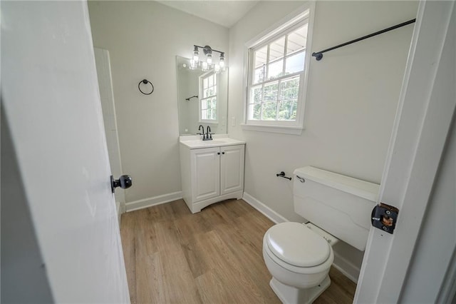 4732 Manly Ct, Stone Mountain, GA 30088 - half bathroom featuring toilet, vanity, wood finished floors, and baseboards