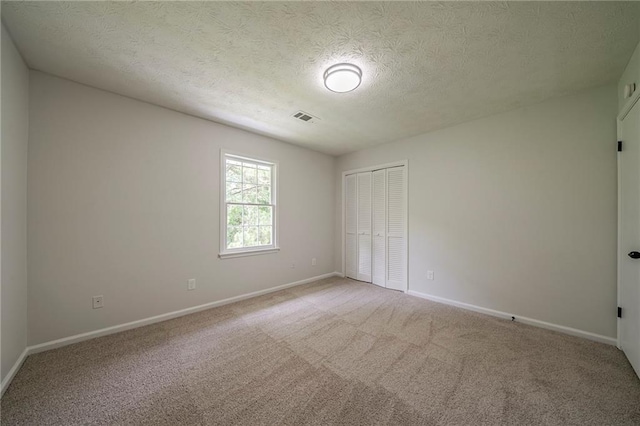 4732 Manly Ct, Stone Mountain, GA 30088 - unfurnished bedroom featuring light colored carpet, a closet, baseboards, and a textured ceiling