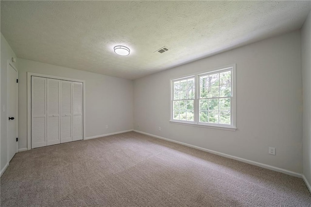 4732 Manly Ct, Stone Mountain, GA 30088 - unfurnished bedroom with baseboards, carpet flooring, a textured ceiling, and a closet
