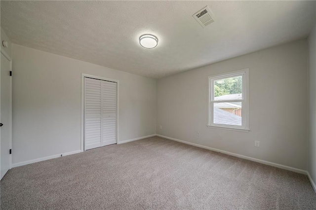 4732 Manly Ct, Stone Mountain, GA 30088 - unfurnished bedroom featuring carpet flooring, a closet, baseboards, and a textured ceiling