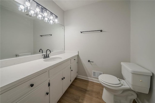 4732 Manly Ct, Stone Mountain, GA 30088 - half bath with toilet, vanity, wood finished floors, and baseboards