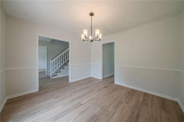 4732 Manly Ct, Stone Mountain, GA 30088 - unfurnished room with a chandelier, light wood-style flooring, baseboards, and stairs